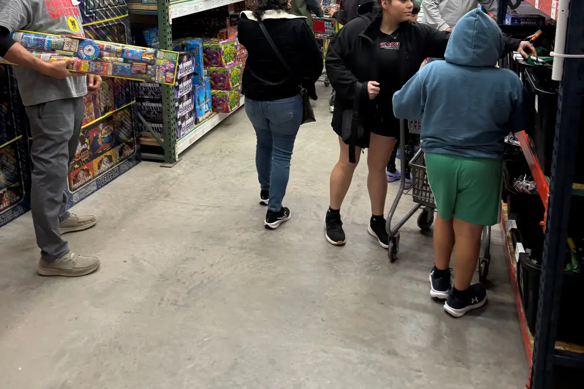 Shoppers under the Raccoon Fireworks banner on New Year's Eve